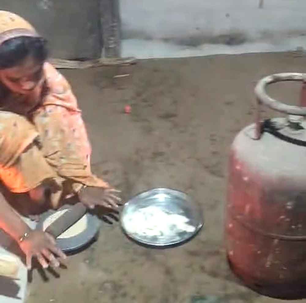 खाली सिलेंडर के सामने चूल्हे पर खाना